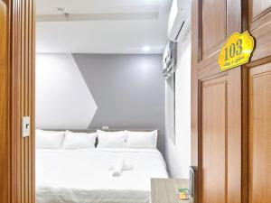 a room with a bed and a sign on the door at Milanesa Hotel and Apartment in Vung Tau