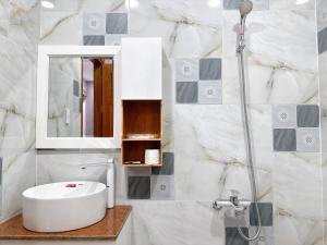 a bathroom with a white sink and a shower at Milanesa Hotel and Apartment in Vung Tau