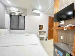 a hotel room with a bed and a flat screen tv at Milanesa Hotel and Apartment in Vung Tau