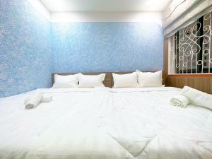 a large white bed in a room with a blue wall at Milanesa Hotel and Apartment in Vung Tau