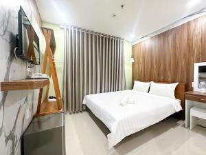 a hotel room with a bed and a television at Milanesa Hotel and Apartment in Vung Tau