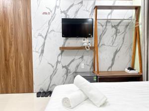 a bedroom with a bed and a tv on a wall at Milanesa Hotel and Apartment in Vung Tau