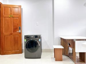 a washing machine in a room next to a door at Milanesa Hotel and Apartment in Vung Tau