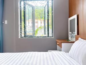 a bedroom with a bed and a window at Milanesa Hotel and Apartment in Vung Tau
