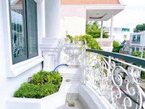 a white balcony with plants on the stairs at Milanesa Hotel and Apartment in Vung Tau