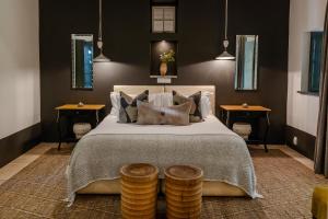 1 dormitorio con 1 cama grande y 2 mesas en Grande Provence, en Franschhoek