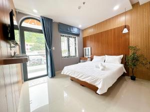 een slaapkamer met een groot bed en een raam bij Milanesa Hotel and Apartment in Vung Tau