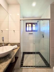 a bathroom with a glass shower and a sink at Casa Pipa Beleza in Pipa