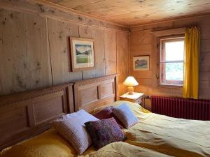 a bedroom with a bed in a room with wooden walls at Chesa Klucker - Fextal in Fex