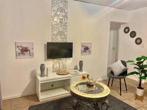 a living room with a tv and a table at Mall of Africa View in Midrand