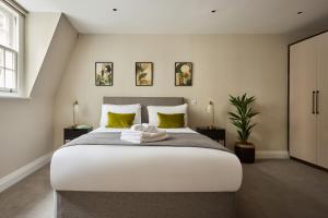 a bedroom with a large white bed with yellow pillows at Chancery Lane by Viridian Apartments in London