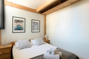 - une chambre avec un lit blanc et un plafond en bois dans l'établissement Les Lumières - Charmant T2 au cœur de Nantes, à Nantes
