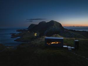 a bed on a hill with a view of the ocean at Birdbox Reksta in Florø