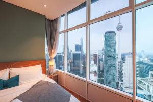 a bedroom with a large window with a city view at Calm Sojourn, Sky Suites KLCC in Kuala Lumpur