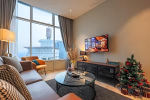 a living room with a christmas tree and a television at Calm Sojourn, Sky Suites KLCC in Kuala Lumpur