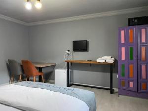 a bedroom with a bed and a desk and a purple door at GÖKBÜK SERENİTY HOTEL in Belbaşı