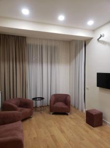 ein Wohnzimmer mit 2 Stühlen und einem Tisch in der Unterkunft Tsereteli flatt 7 in Tbilisi City
