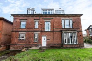 an old red brick building with a white door at Cosy Studio Apartment in Derby by Renzo, Brilliant Location, Close to Derby City Centre in Derby