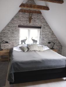 a bedroom with a large bed and a brick wall at Ezzo guest house in Nakskov