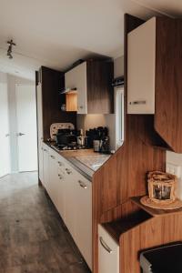 a kitchen with wooden cabinets and a counter top at Hoeve Twente - De Buizerd in Heythuysen