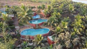 einen Luftblick auf einen Pool mit Palmen des Resorts in der Unterkunft Fazlani Natures Nest- The Wellness Retreat in Lonavla