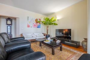 a living room with a leather couch and a table at Villa Magnólia in Funchal