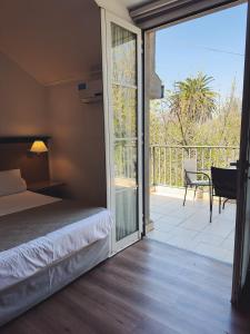 a bedroom with a bed and a sliding glass door at Argentino Hotel in Mendoza