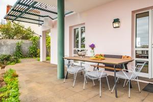 a patio with a wooden table and chairs at Villa Magnólia in Funchal