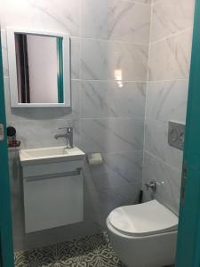 a bathroom with a toilet and a sink and a mirror at Bella Casetta Guest House in Famagusta