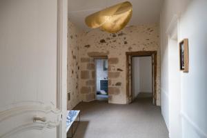 un pasillo con una lámpara de oro en el techo en Les Chambres du Cloître, en Limoges