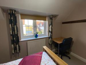 - une chambre avec un lit, un bureau et une fenêtre dans l'établissement Cottage in Bretforton, north of the Cotswolds, à Bretforton