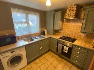 a kitchen with a sink and a washing machine at Cottage in Bretforton, north of the Cotswolds in Bretforton