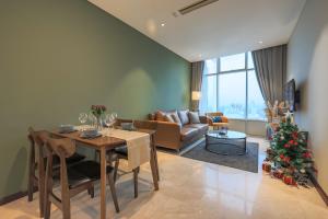a living room with a table and a christmas tree at Calm Sojourn, Sky Suites KLCC in Kuala Lumpur