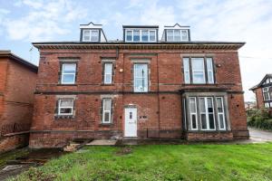 an old red brick building with a white door at Bright and Warm Studio Apartment in Derby by Renzo, Brilliant Location, Free Parking! in Derby