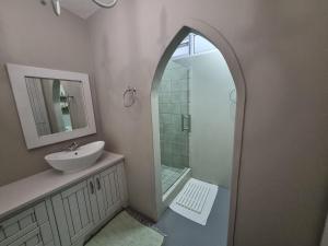 a bathroom with a sink and a shower with a mirror at Manatoka Unit 1 in Jacobs Bay