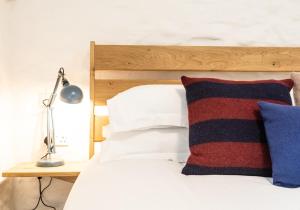 una camera da letto con letto con testata in legno e lampada di Y Stabl - perfect for two a Saint Dogmaels