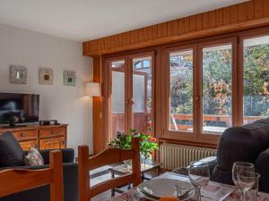 - un salon avec une table, des chaises et des fenêtres dans l'établissement Apartment Derborence 25 by Interhome, à Nendaz