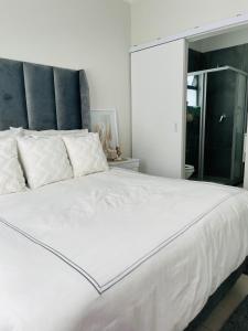 a large white bed in a room with a window at Apollo one bedroom in Sandton