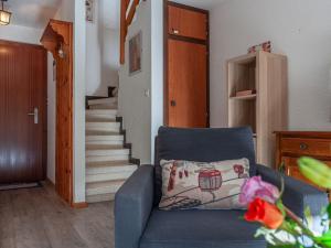 a living room with a blue couch and stairs at Apartment Derborence 25 by Interhome in Nendaz