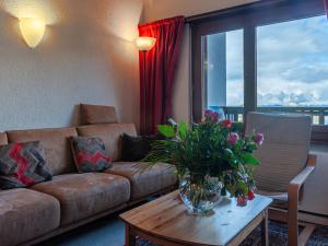 Una sala de estar con un sofá y una mesa con flores. en Apartment Anemone 9 by Interhome, en Nendaz 29 fotos más
