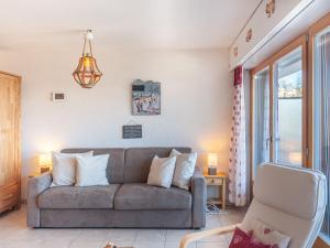 a living room with a couch and a chair at Apartment Panoramic B1 by Interhome in Nendaz