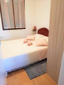 een slaapkamer met een bed met roze kussens en een raam bij Serenity by the sea #3 - private terrace in Vrsi