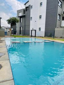 a swimming pool with blue water in front of a building at Apollo one bedroom in Sandton