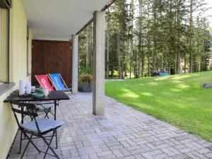 eine Terrasse mit einem Tisch und Stühlen neben einem Hof in der Unterkunft Apartment Allod-Park-15 by Interhome in Davos