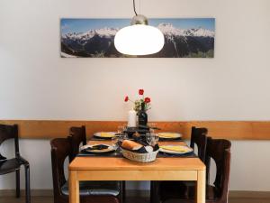 a table with plates of food on it with mountains at Apartment Allod Park Haus C 301 by Interhome in Davos