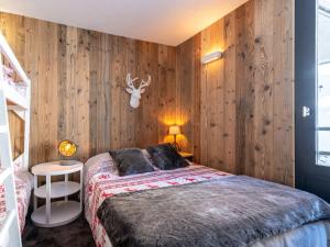 a bedroom with a bed and wooden walls at Apartment Le Bollin - Val Claret-4 by Interhome in Tignes