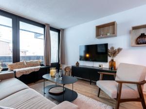 a living room with a couch and a tv at Apartment Le Bollin - Val Claret-4 by Interhome in Tignes