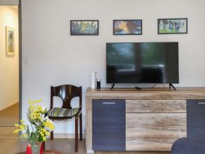 a living room with a television on a wooden entertainment center at Apartment Allod-Park-46 by Interhome in Davos