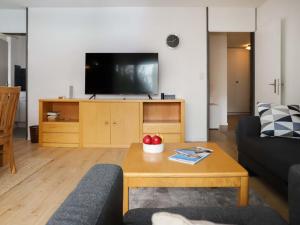 a living room with a couch and a tv at Apartment Allod Park Haus C 205 by Interhome in Davos