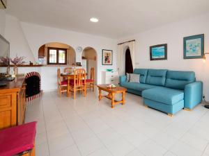 a living room with a blue couch and a table at Holiday Home Mara by Interhome in Casas de Torrat